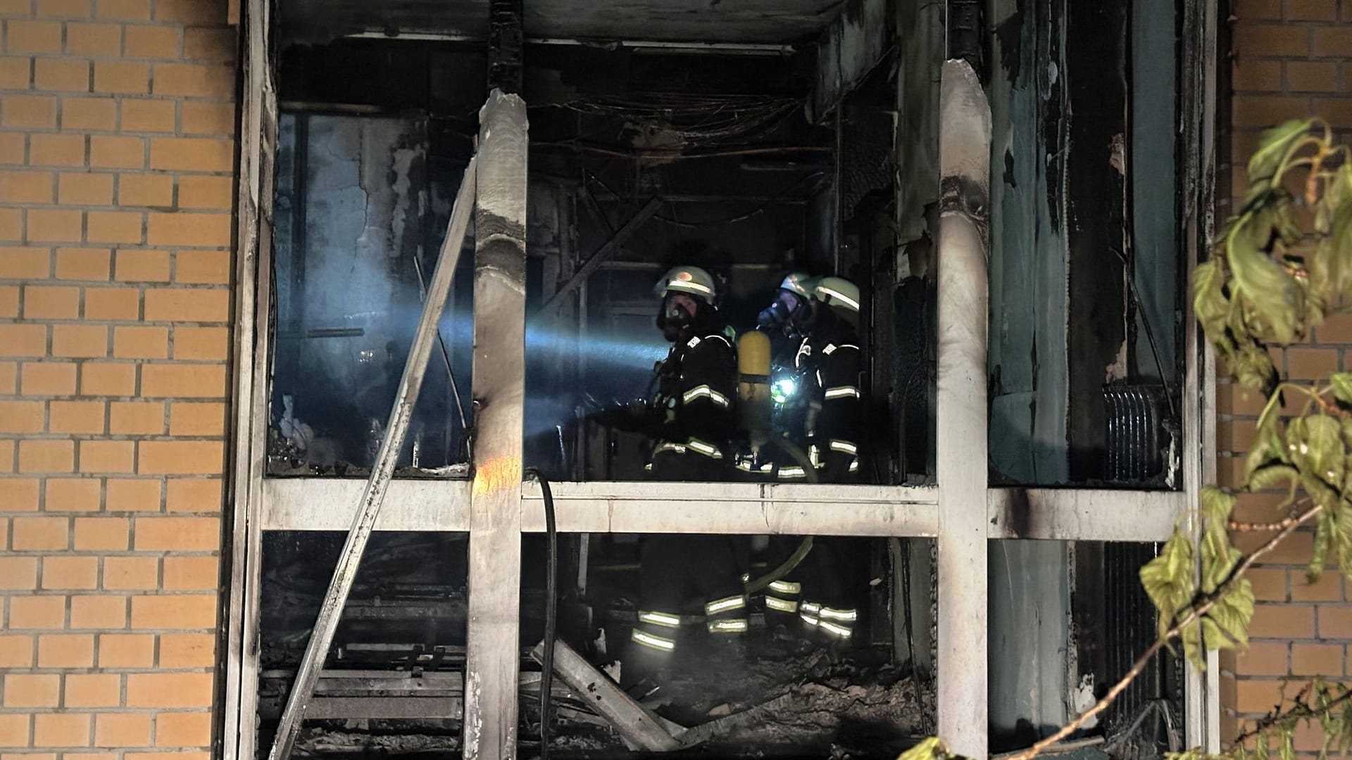 Feuerwehrleute mit Atemschutzgerät arbeiten in einem ausgebrannten Raum im Marienkrankenhaus in Hamburg: Ein Mensch schwebt noch in Lebensgefahr.