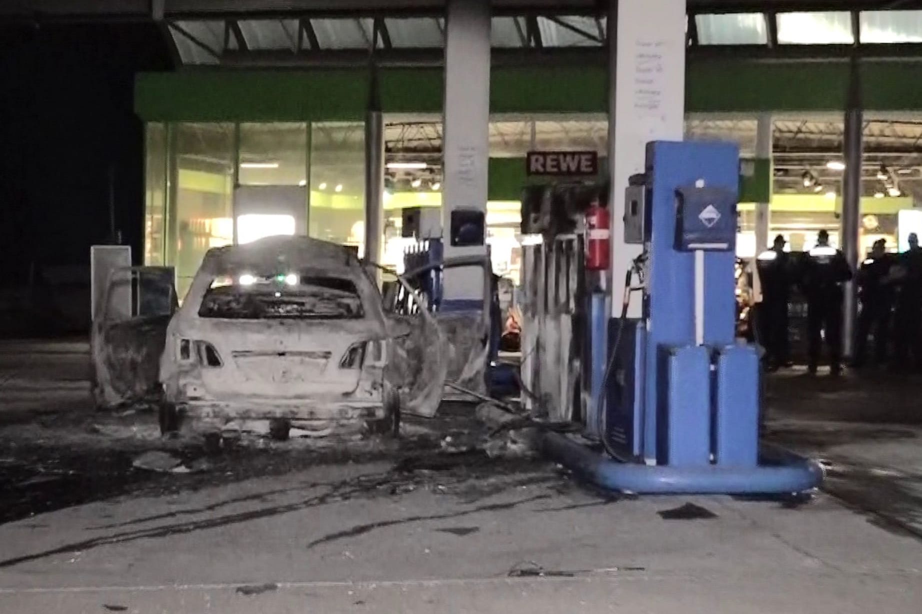 Mann fährt brennendes Auto an Tankstelle