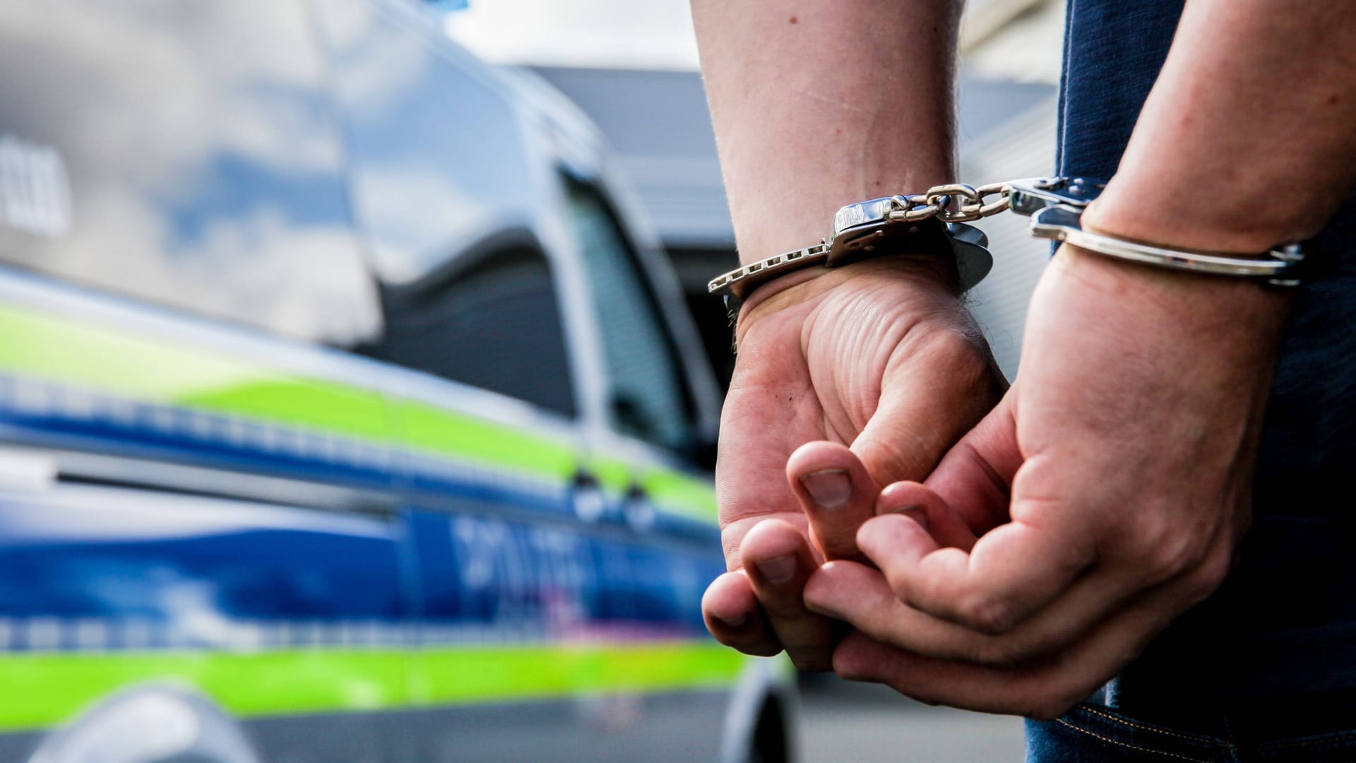 Person in Handschellen neben einem Polizeifahrzeug (Symbolbild): Der Mann soll insgesamt zwölf Diebstähle begangen haben. Person in Handschellen neben einem Polizeifahrzeug (Symbolbild): Der Mann soll insgesamt zwölf Diebstähle begangen haben.