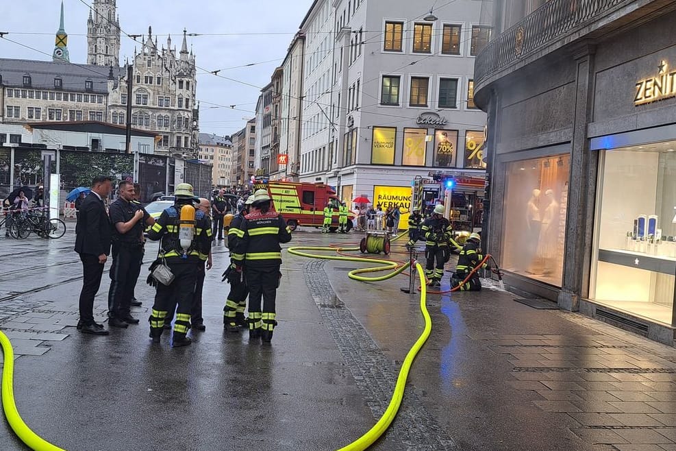 Einsatzkräfte der Feuerwehr München bei dem Brand in der Innenstadt. Dunkler Rauch drang nach außen. Die Ursache muss noch gefunden werden.