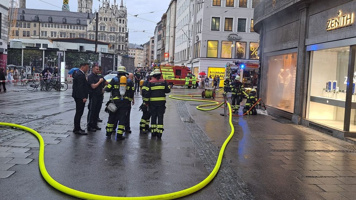 Einsatzkräfte der Feuerwehr München bei dem Brand in der Innenstadt. Dunkler Rauch drang nach außen. Die Ursache muss noch gefunden werden.