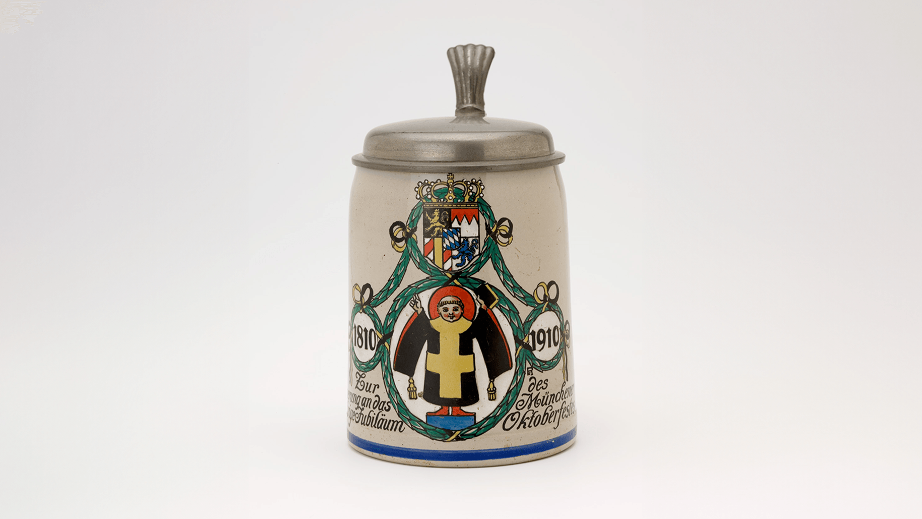 Bierkrug zum Oktoberfest-Jubiläum 1910: Das Münchner Kindl als zentrale Figur zeigt, wie stark es bereits im frühen 20. Jahrhundert mit der Stadtidentität verknüpft war.