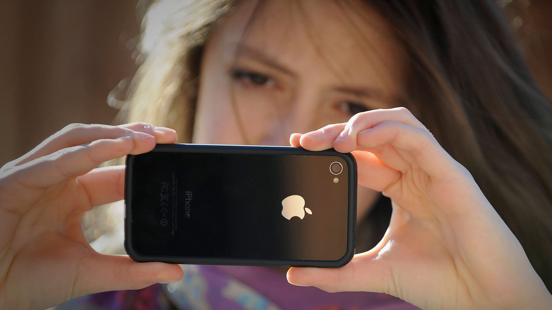 Kind mit Smartphone: Handys und soziale Medien bergen Risiken, aber ist ein Verbot die richtige Lösung?