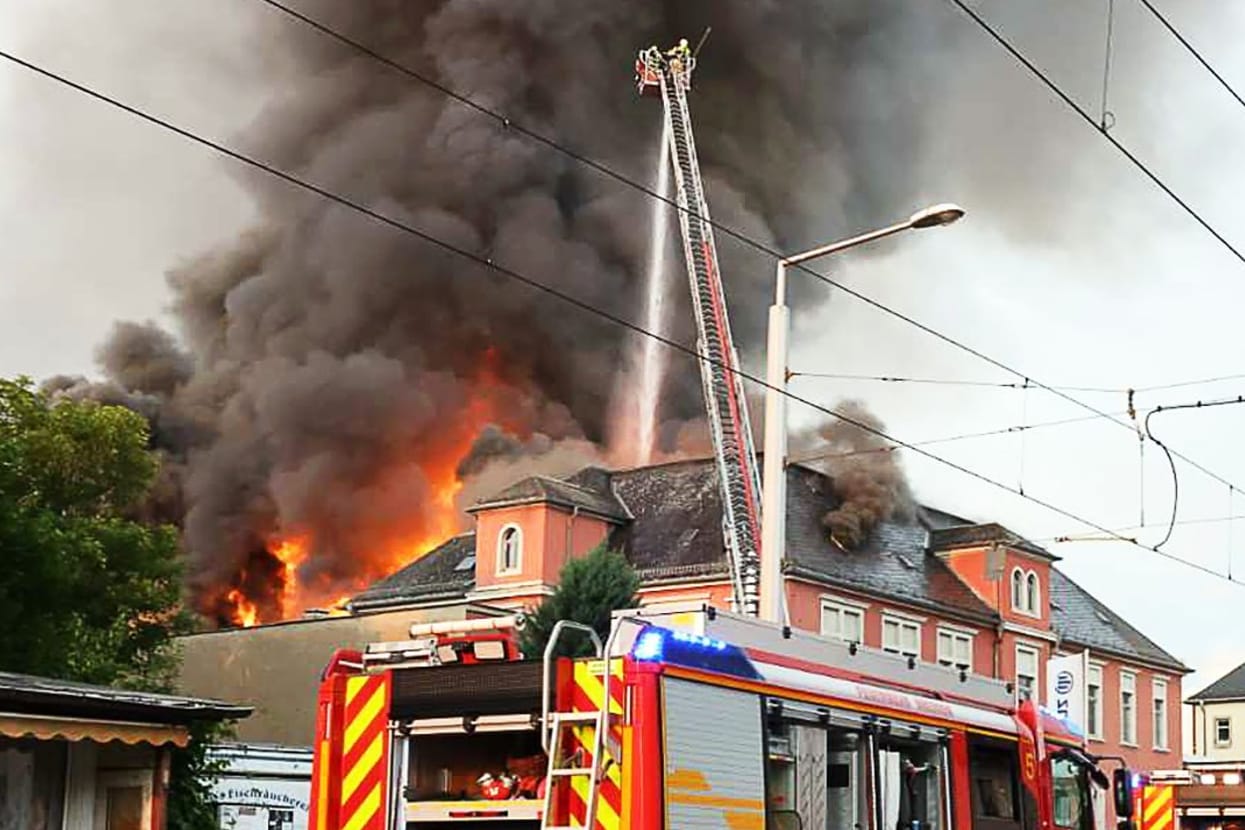 Einsatzkräfte der Feuerwehr bei den Löscharbeiten des Großbrands im früheren Domizil der Staatsoperette in Leuben am Freitagabend.