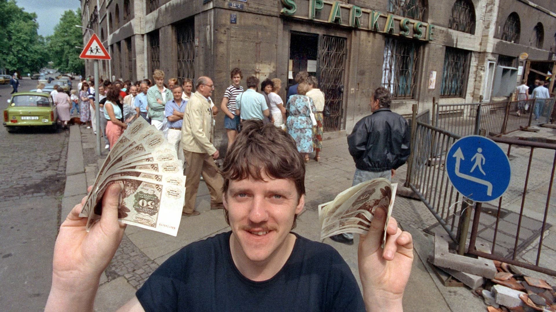Ein junger Mann freut sich am 1. Juli 1990 über seine D-Mark.
