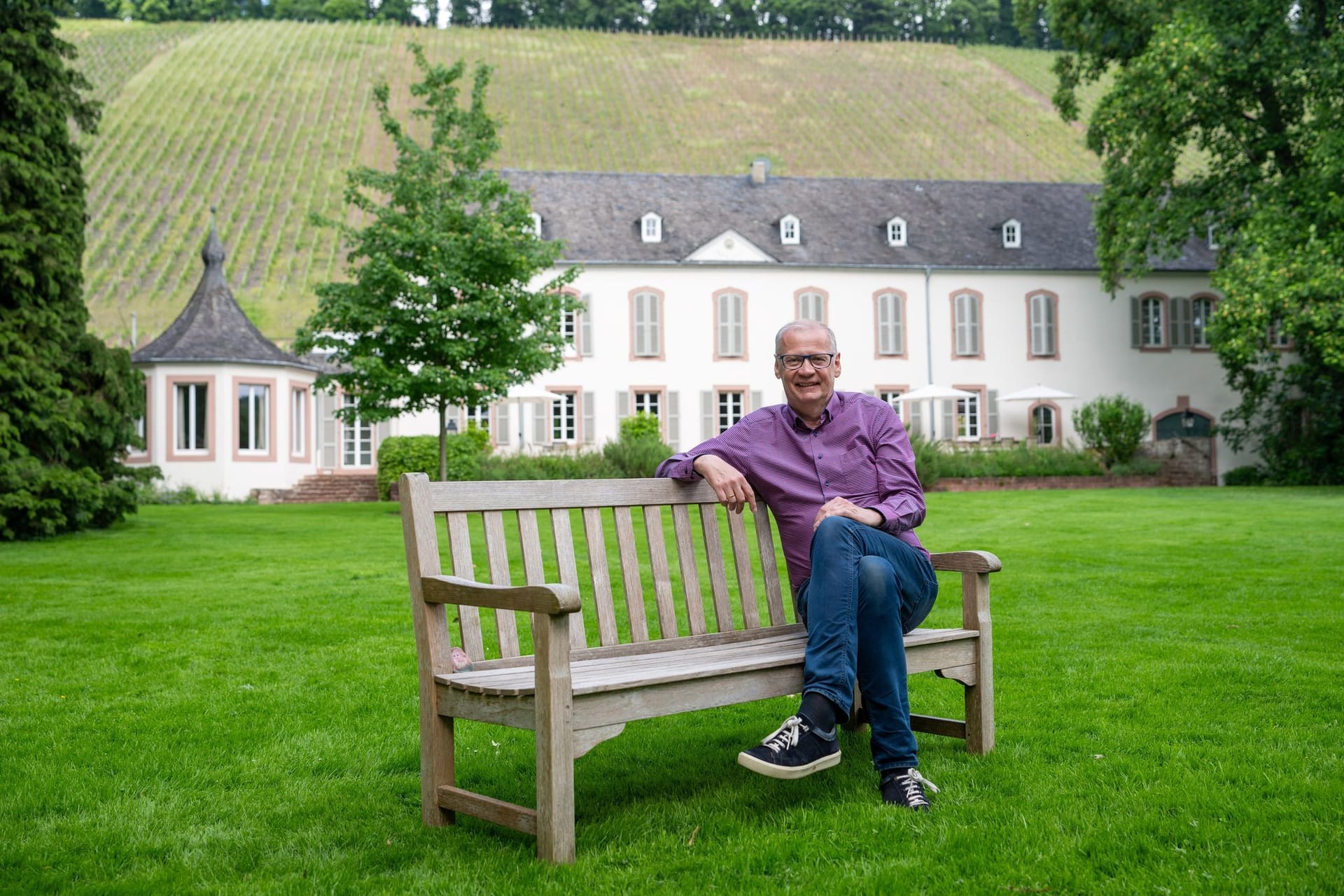 Günther Jauch auf einer Bank vor seinem Weingut an der Saar.