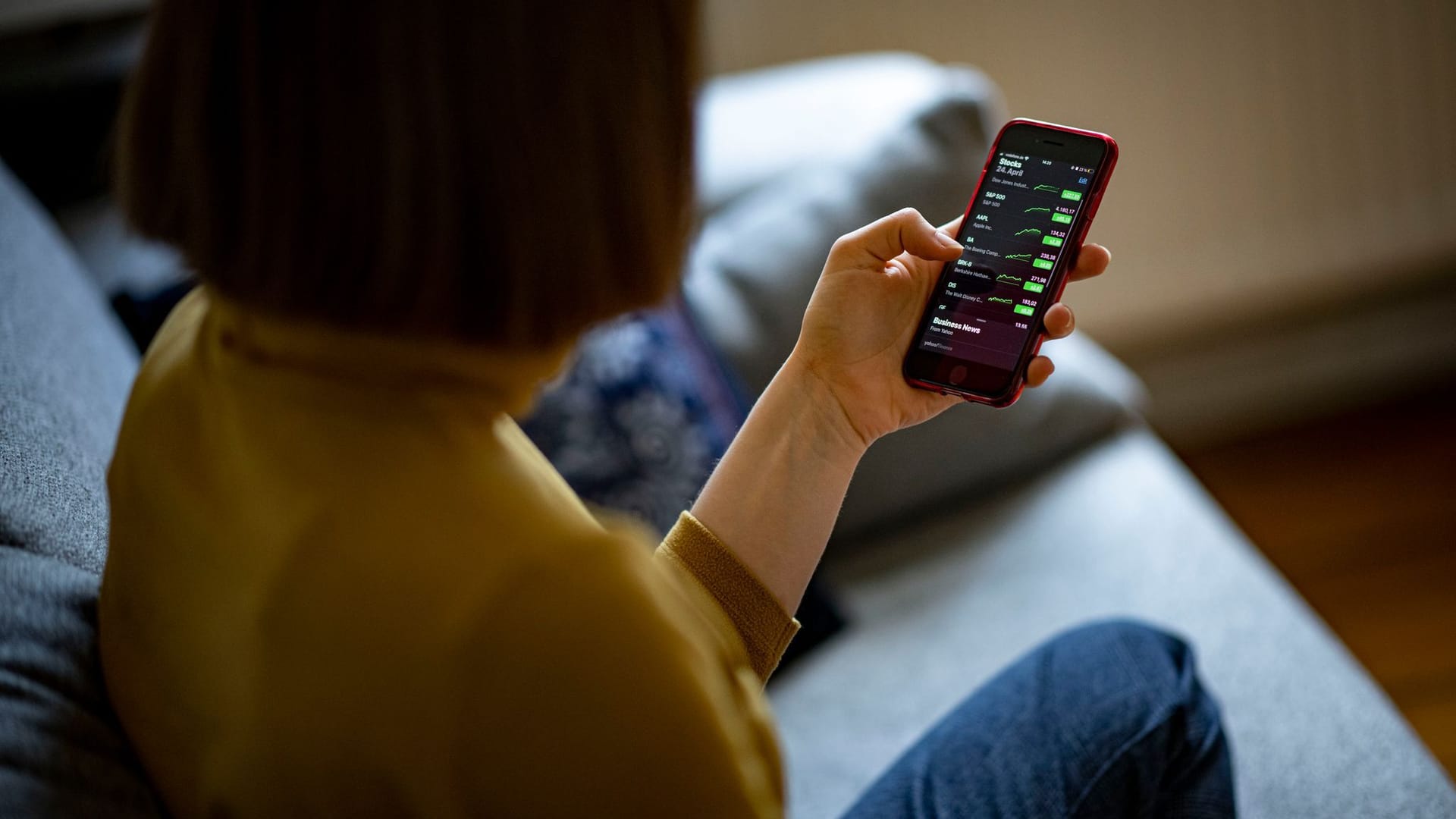 Eine Frau ruft Aktienkurse auf einem Smartphone auf