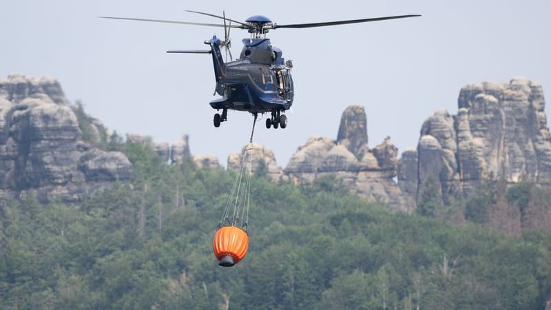 Ein Hubschrauber fliegt über einem Löschwasser-Bassin (Archivbild): Die verheerenden Waldbrände im Sommer 2022 haben ein letztes Alarmsignal gewirkt.