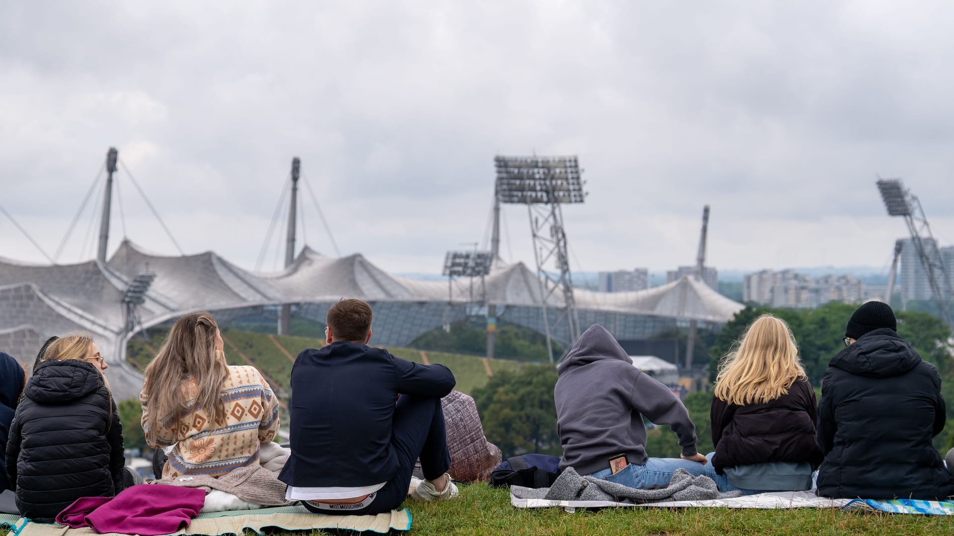 Fans sitzen auf Decken mit Blick auf das Olympiastadion: Stunden vor dem Robbie-Williams-Konzert sicherten sie sich ihre Plätze am Hang.