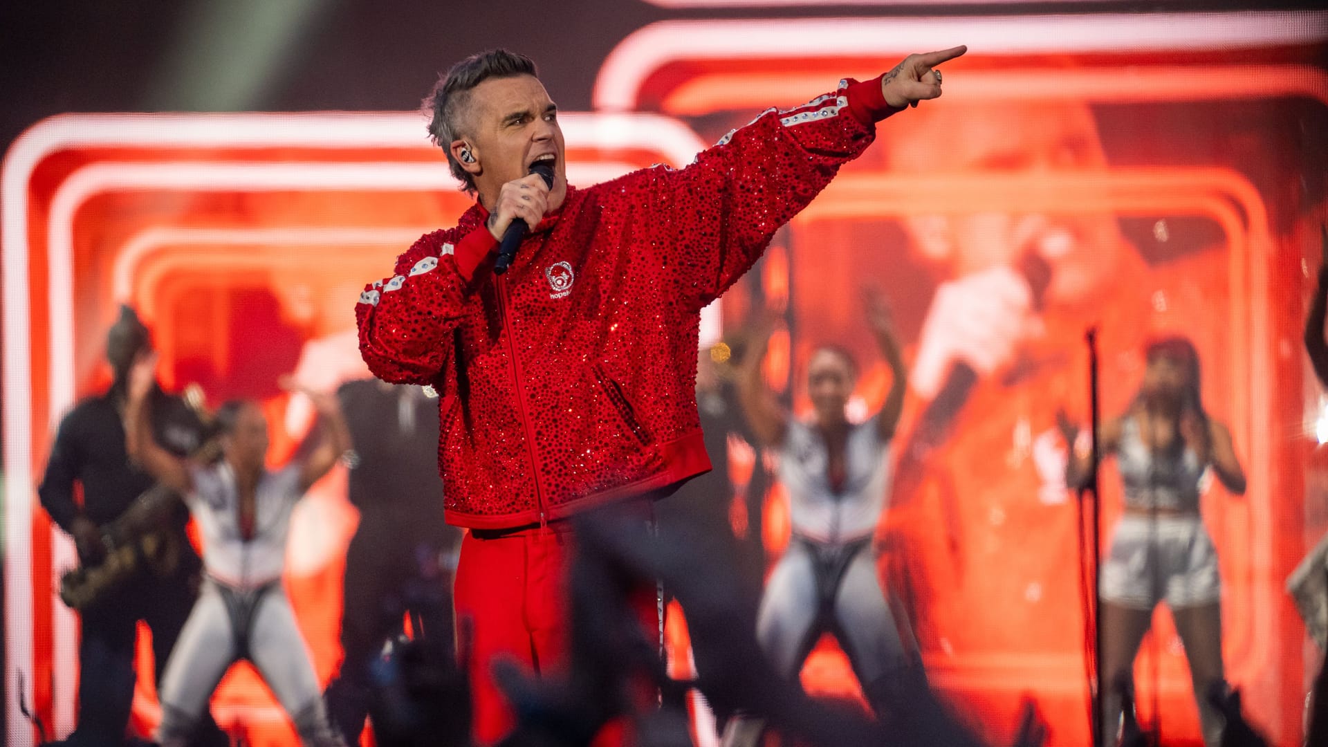 Robbie Williams im roten Glitzeranzug bei seinem Hit "Let Me Entertain You": Mit viel Energie, Humor feuerte der Popstar ein Show-Spektakel der Extraklasse ab.