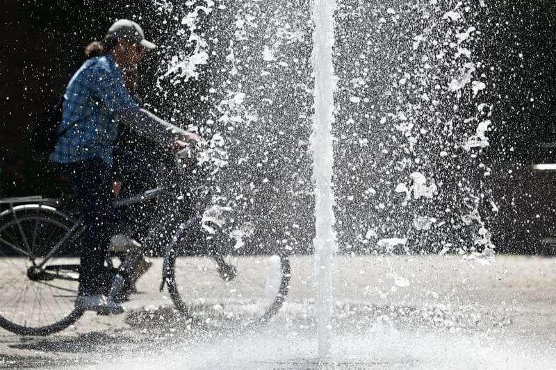 Ein Radfahrer fährt an einem Brunnen vorbei (Archivbild): In Hessen sollen die Thermometer heute auf bis zu 40 Grad klettern.