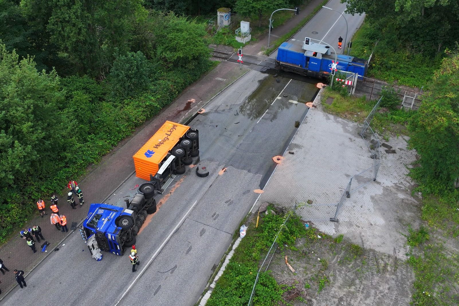 Hamburg Wilhelmsburg - Nippoldstraße - LKW gegen Hafenbahn am Bahnübergang- LKW auf Seite - Fahrer verletzt - Flüssigkeit tritt aus
