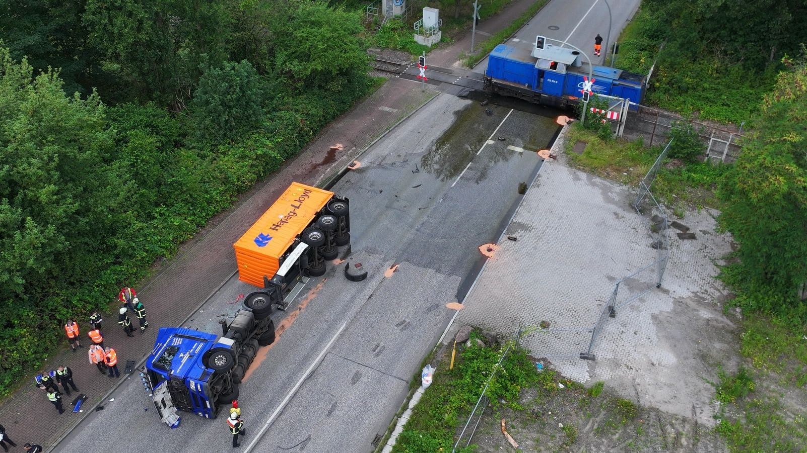 Hamburg Wilhelmsburg - Nippoldstraße - LKW gegen Hafenbahn am Bahnübergang- LKW auf Seite - Fahrer verletzt - Flüssigkeit tritt aus
