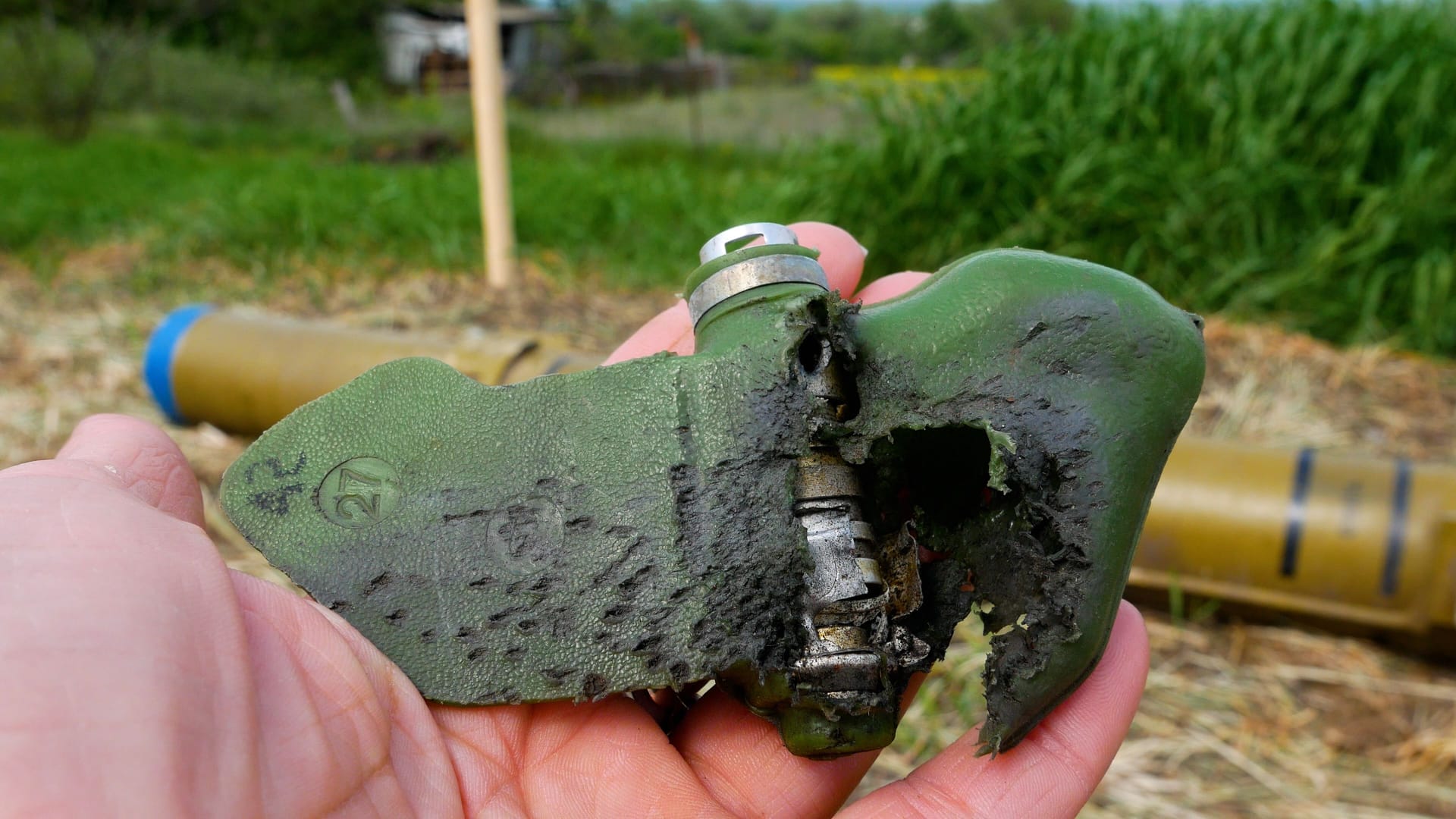 A detonated anti-personnel mine, a petal with traces of an explosion in the hand. Demining. War
