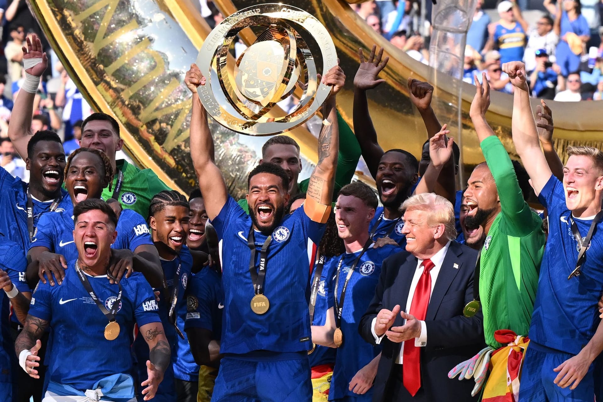 Seltsam: Chelseas Reece James (M.) jubelt mit der Trophäe im Beisein von US-Präsident Donald Trump (3.v.r.).