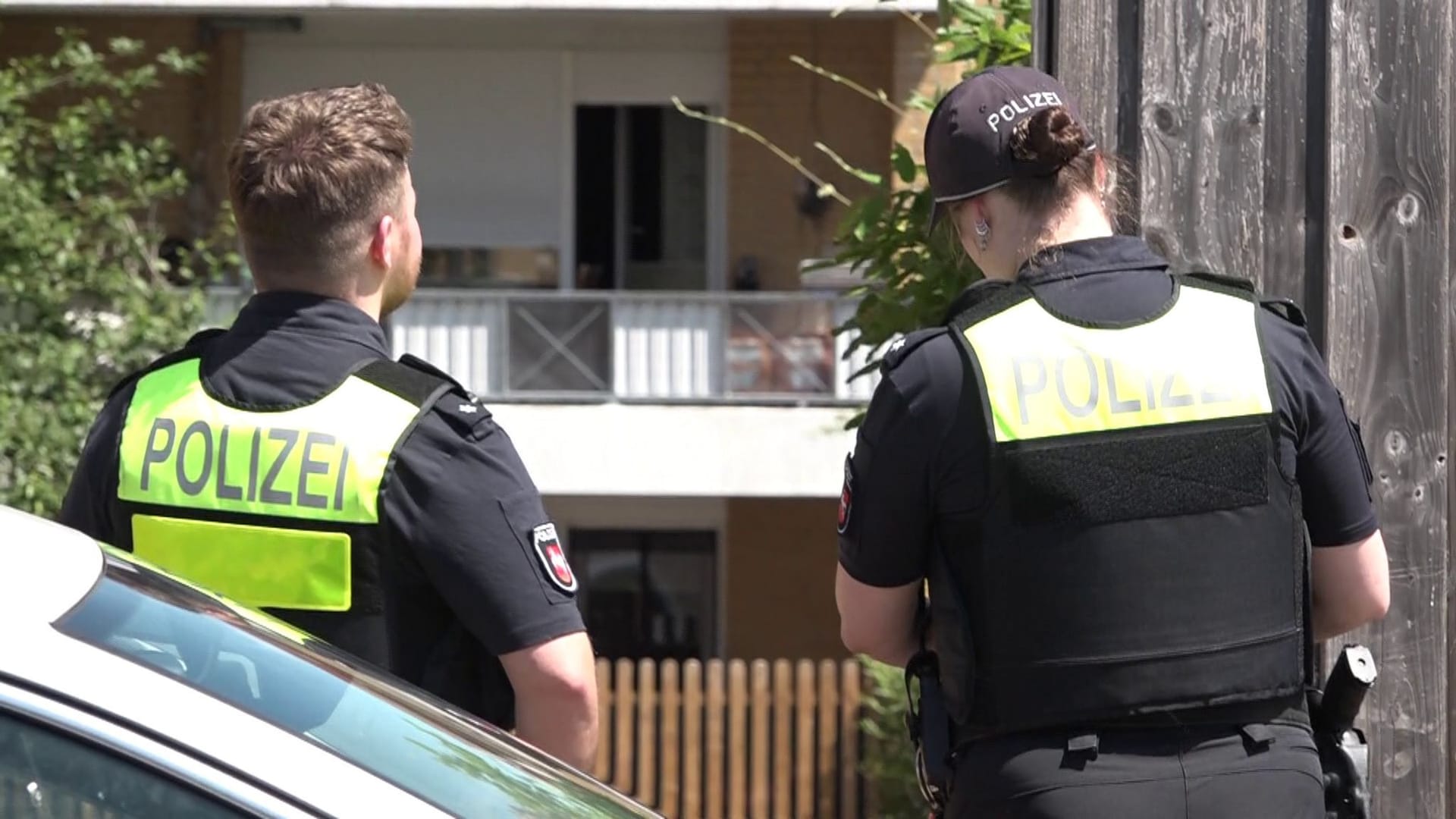 Zwei Polizisten stehen vor einem Mehrfamilienhaus in der Gemeinde Hemmingen. Am Freitagvormittag wird die Polizei hier zu einem Tatort gerufen.