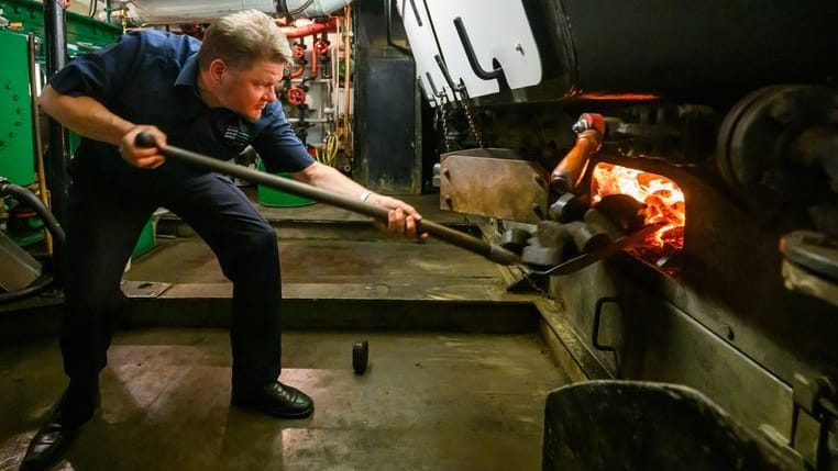 Falk Hering, Maschinist auf dem Raddampfer «Diesbar» der Sächsischen Dampfschifffahrt Weiße Flotte, schaufelt Kohlen in den Kessel des historischen Schiffes.