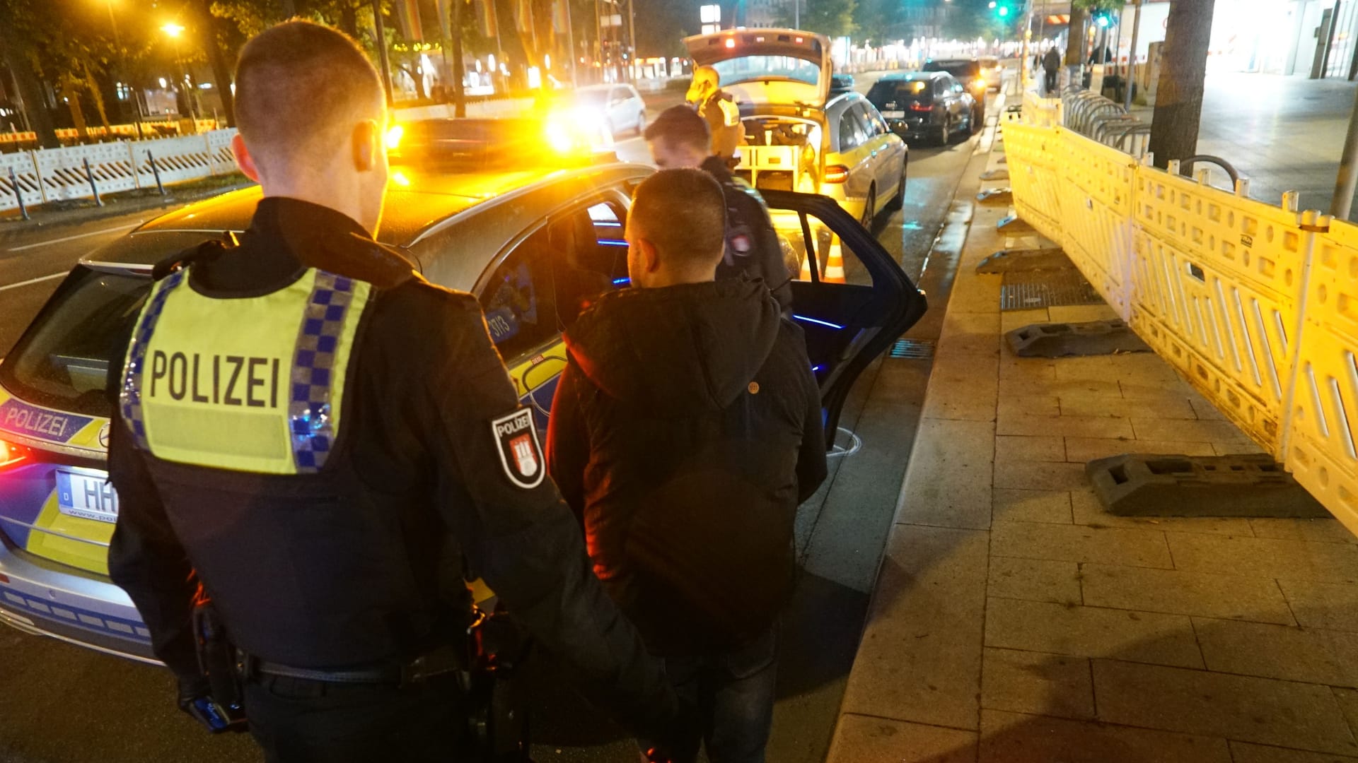 Ein Hamburger Polizist steht vor einem Mann: In der späten Mittwochnacht wurden zwei Männer vorläufig festgenommen. Ein Hamburger Polizist steht vor einem Mann: In der späten Mittwochnacht wurden zwei Männer vorläufig festgenommen.