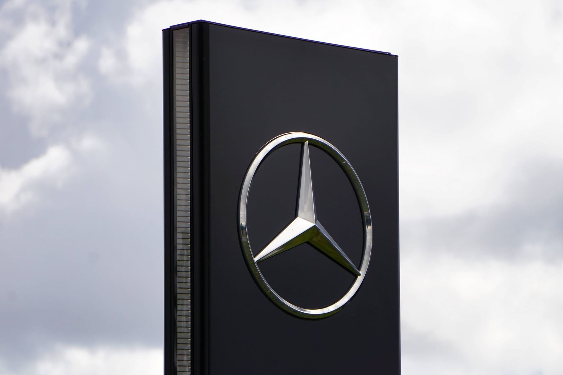 Mercedes-Logo vor einer Verkaufsfiliale (Symbolbild): Der Gewinn des Autobauers ist massiv eingebrochen.