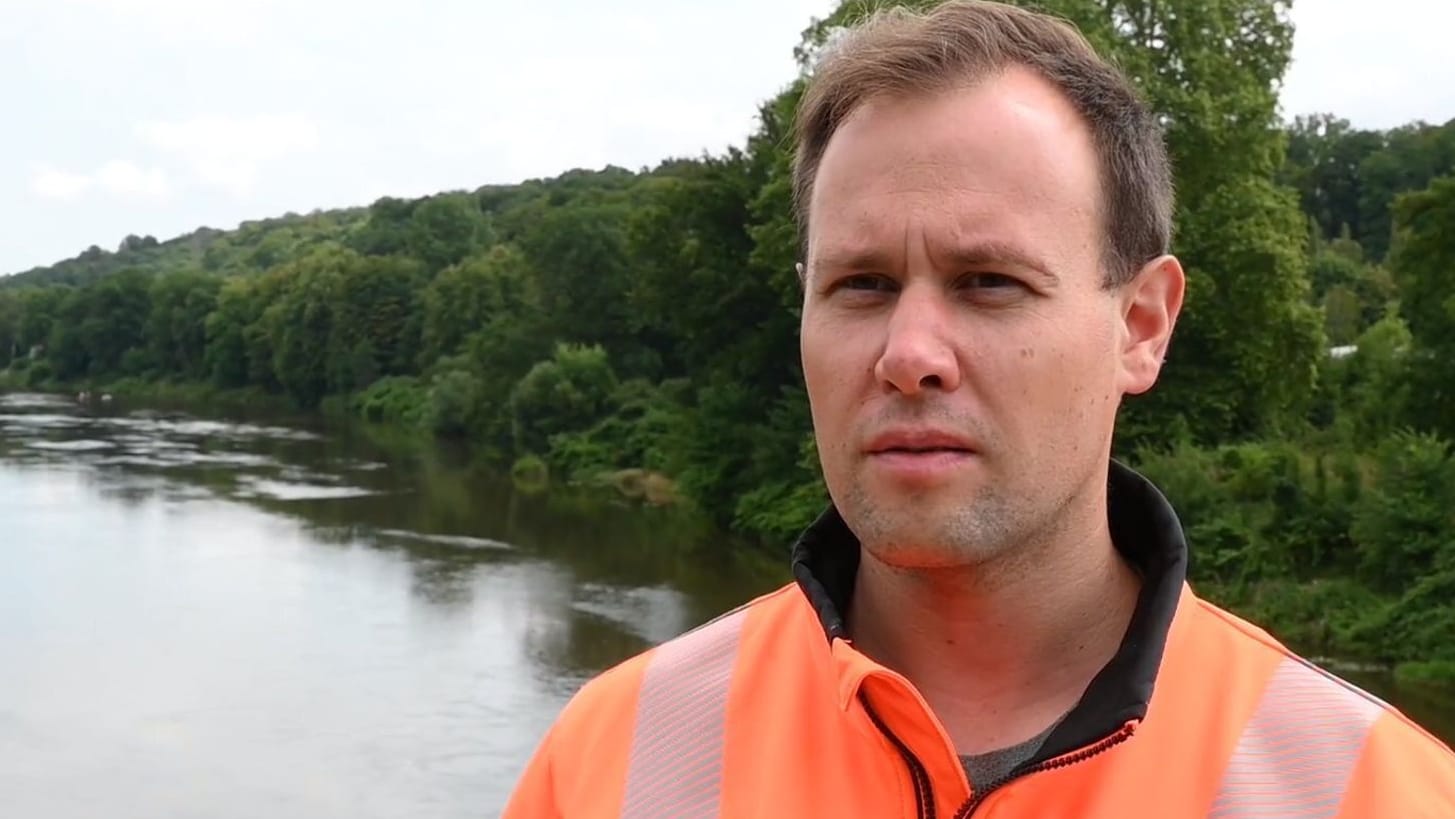 Grimmas Oberbürgermeister Tino Kießig steht auf einer Brücke in der Nähe der Absturzstelle eines Hubschraubers: Er ist als Feuerwehrmann im Einsatz.