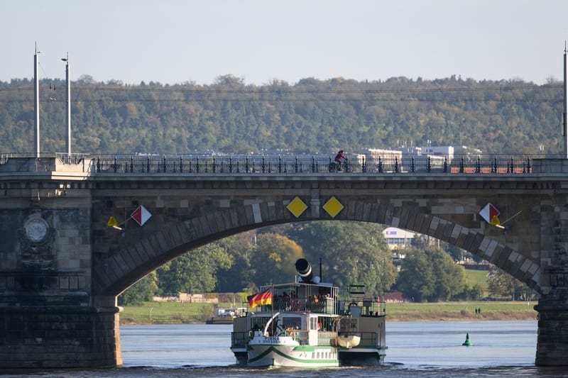 Der historische Schaufelraddampfer „Pirna“ der Sächsischen Dampfschifffahrt fährt am Vormittag auf der Elbe unter der Albertbrücke hindurch: Die Weiße Flotte kann wieder häufiger fahren.