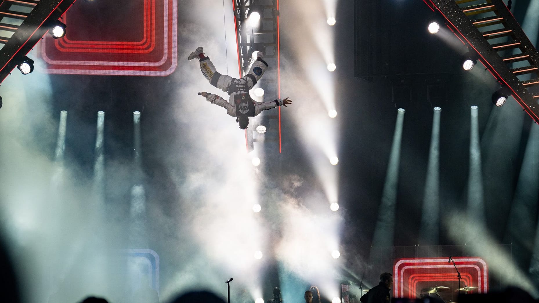Robbie Williams schwebt kopfüber auf die Bühne des Olympiastadions: Der Auftakt läutete das Entertainment-Feuerwerk des Abends ein.