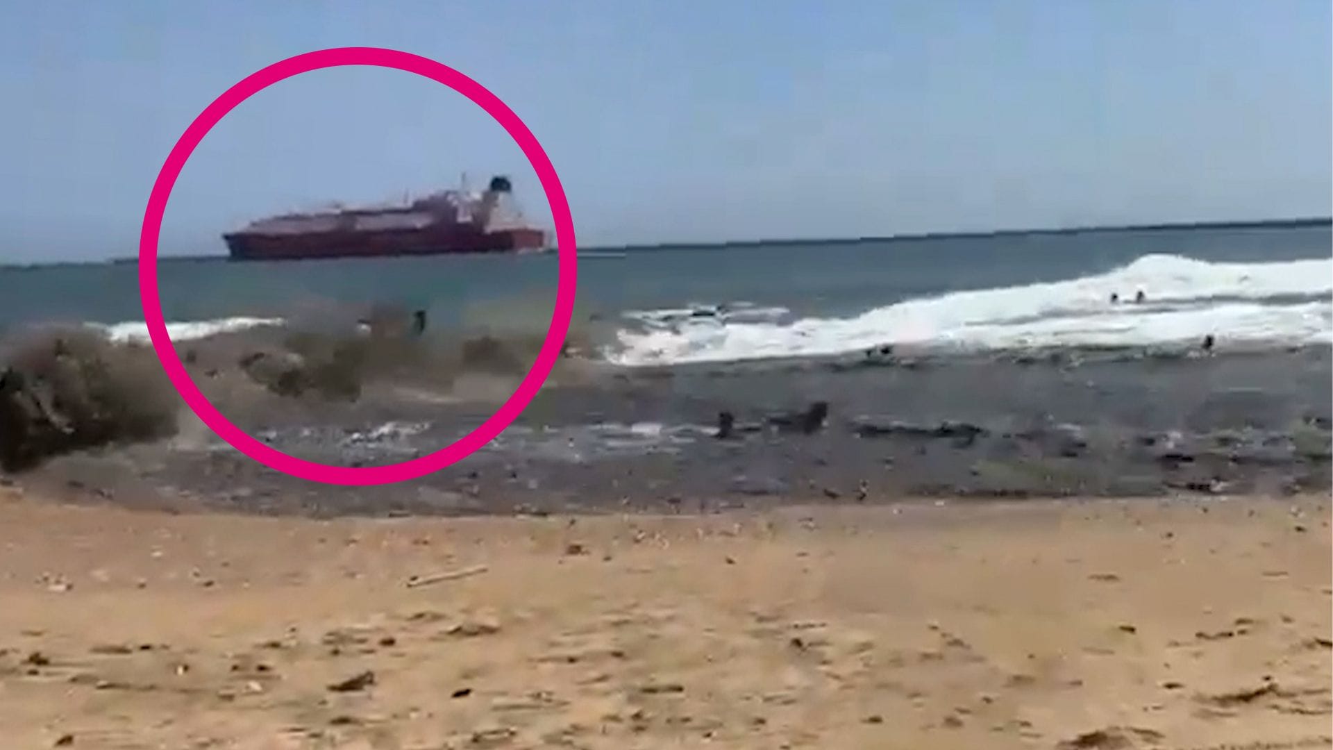 Eine enorme Welle spült mehrere Badegäste an den Strand.