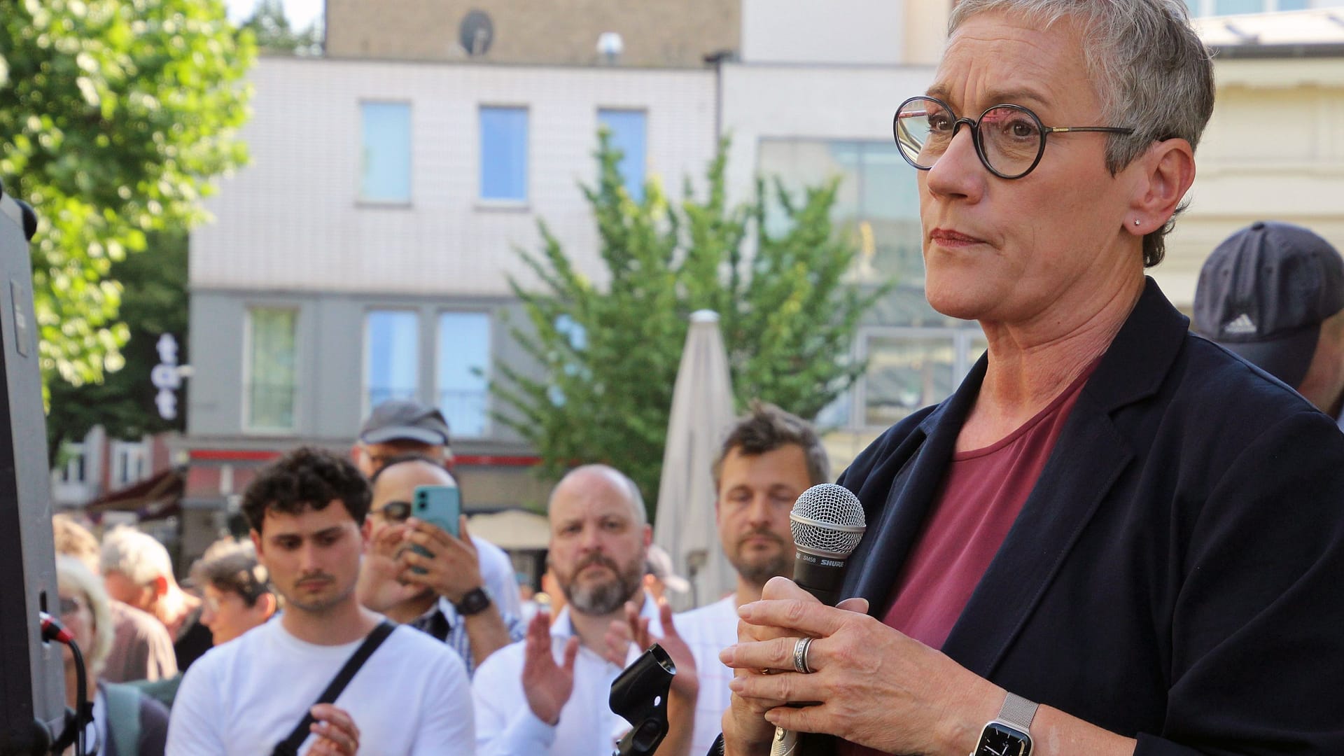 Sibylle Keupen am Mikrofon, Lukas Benner (l,. Grüne) und Michael Ziemons (r., CDU) im Hintergrund: Die Politiker bekundeten direkt nach dem Angriff Solidarität.