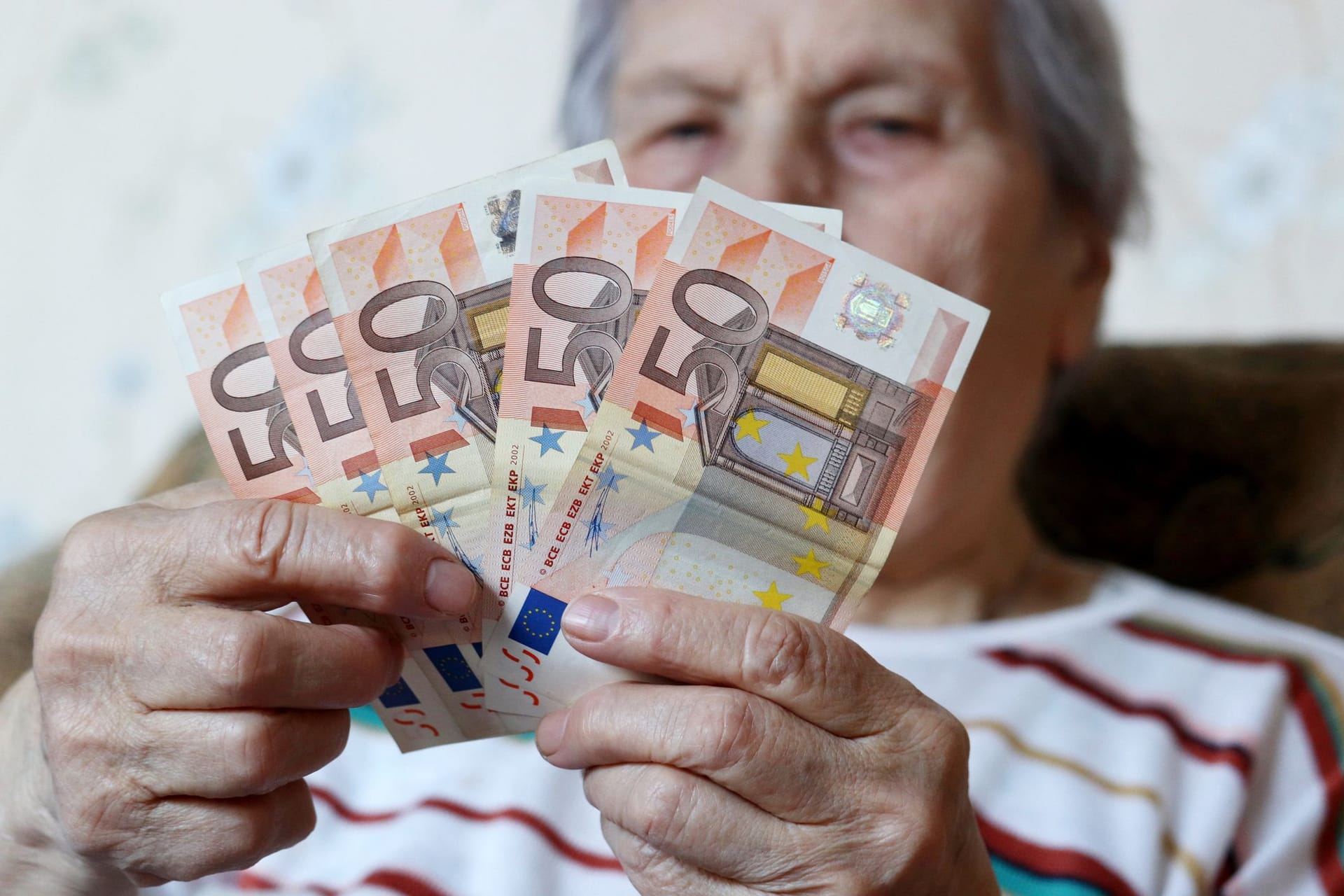 Rentnerin hält Geldscheine: Noch kann man sich die Rente auf Wunsch bar auszahlen lassen. Rentnerin hält Geldscheine: Noch kann man sich die Rente auf Wunsch bar auszahlen lassen.