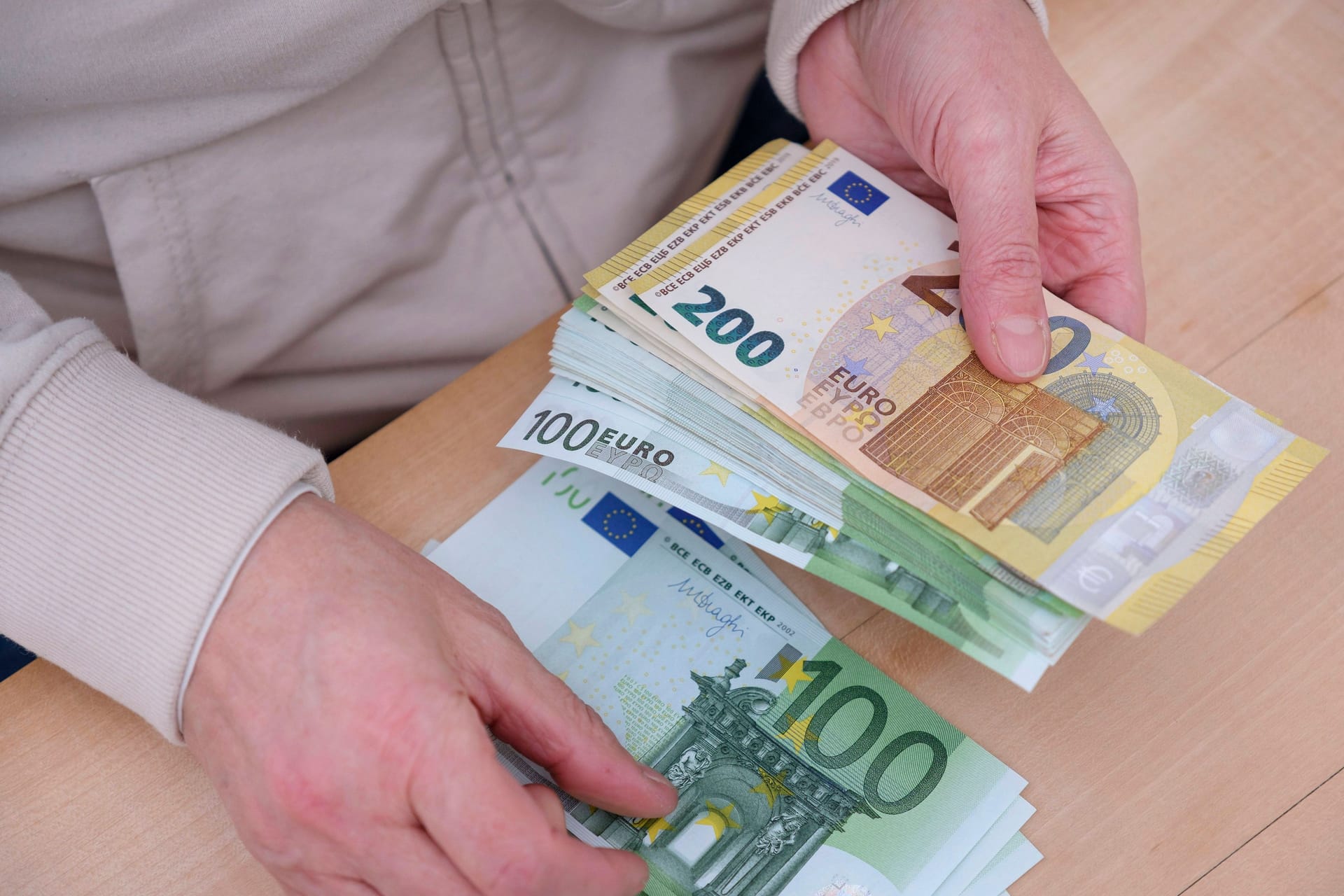 Frau zählt Euro Scheine (Symbolfoto): In Hamburg verdienen Vollzeitbeschäftigte im Mittel mehr als in jedem anderen Bundesland.