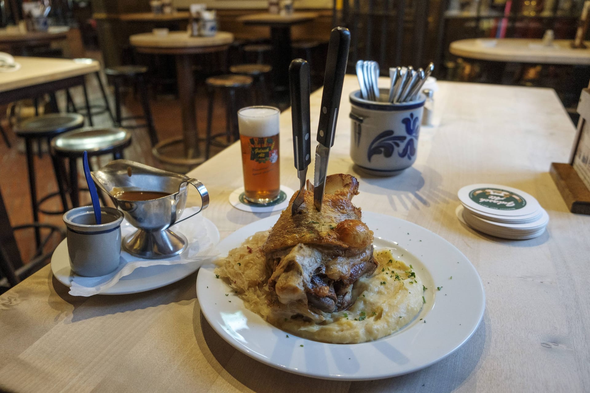 Schweinshaxe und volles Glas Altbier auf einem Tisch (Archivbild): Im Brauhaus Alter Bahnhof in Düsseldorf-Oberkassel entdeckten Lebensmittelkontrolleure ekelerregende Zustände.