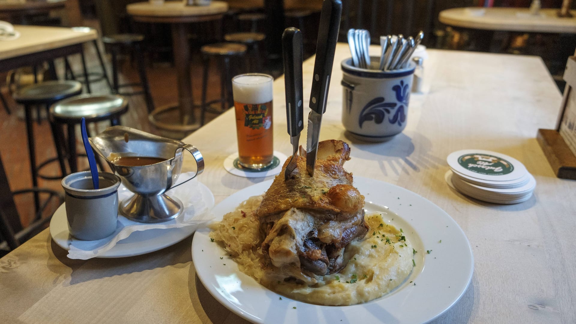 Schweinshaxe und volles Glas Altbier auf einem Tisch (Archivbild): Im Brauhaus Alter Bahnhof in Düsseldorf-Oberkassel entdeckten Lebensmittelkontrolleure ekelerregende Zustände.