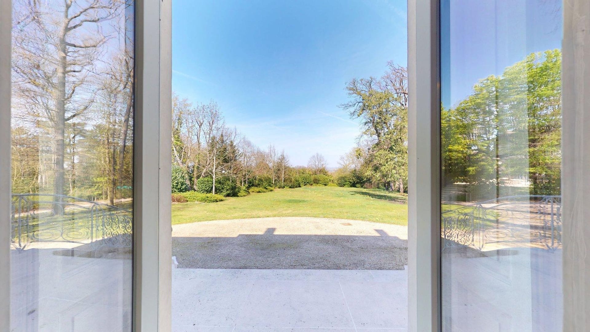 Der Blick vom Empfangsbereich des Hauptgebäudes auf den weiträumigen Park des Anwesens