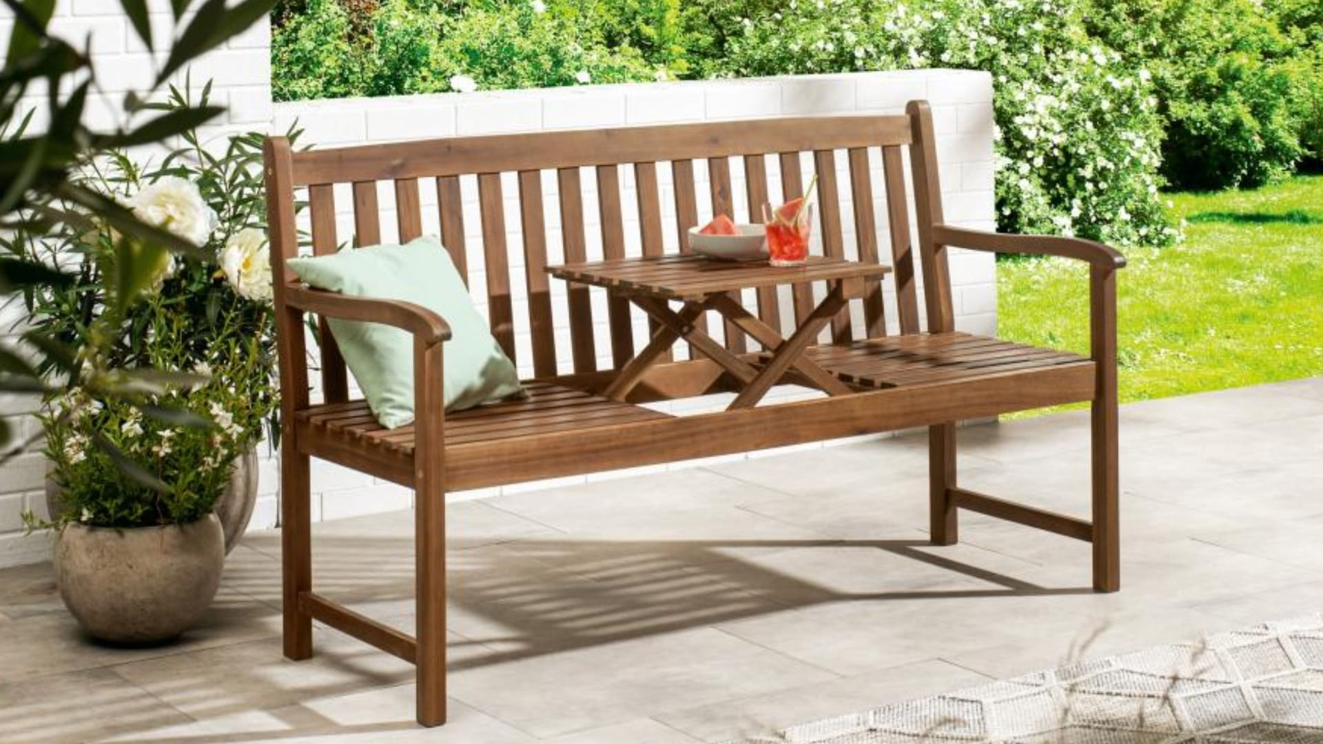 Schlicht, stabil und praktisch: Diese Gartenbank bietet Platz für drei Personen und hat einen integrierten Klapptisch.