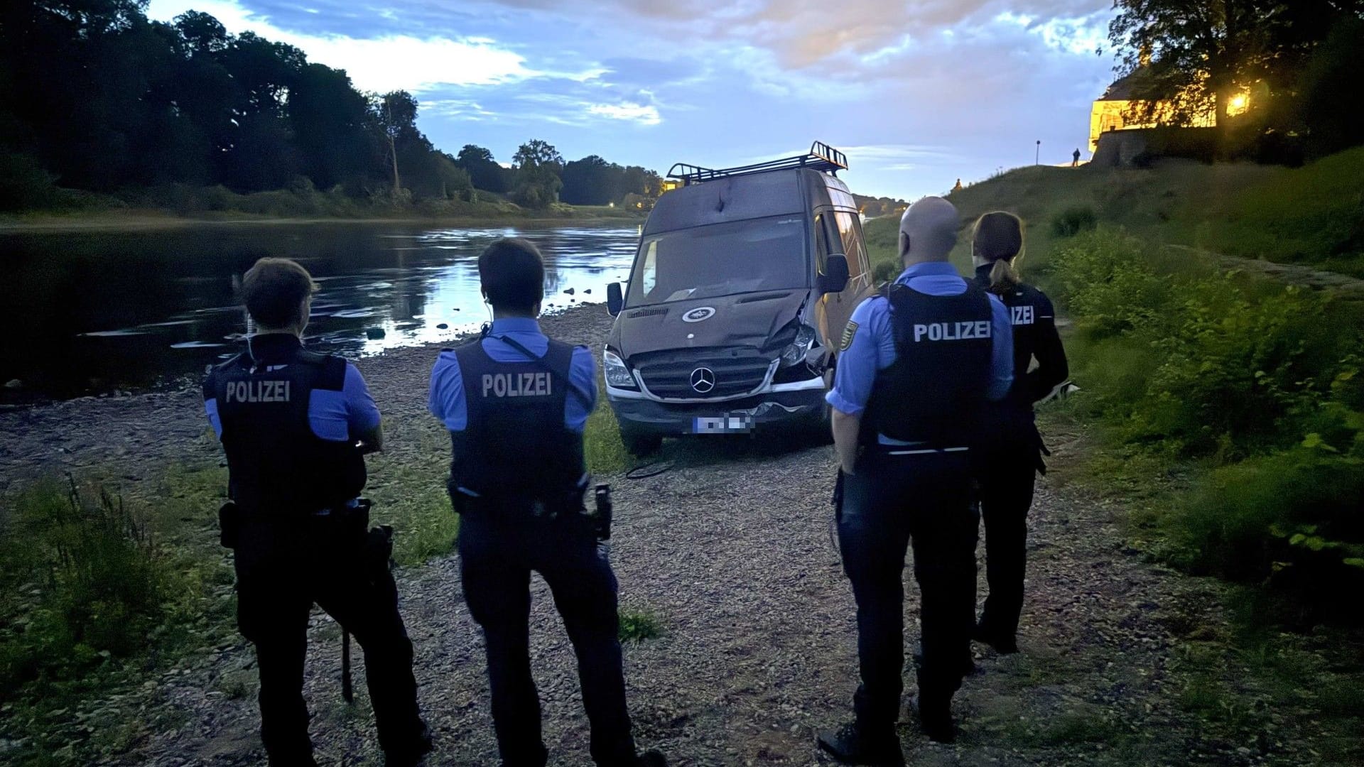 Dresdner Polizeibeamte mit dem verunglückten Transporter an der Elbe: Der Fahrer des Wagens wurde festgenommen. Dresdner Polizeibeamte mit dem verunglückten Transporter an der Elbe: Der Fahrer des Wagens wurde festgenommen.