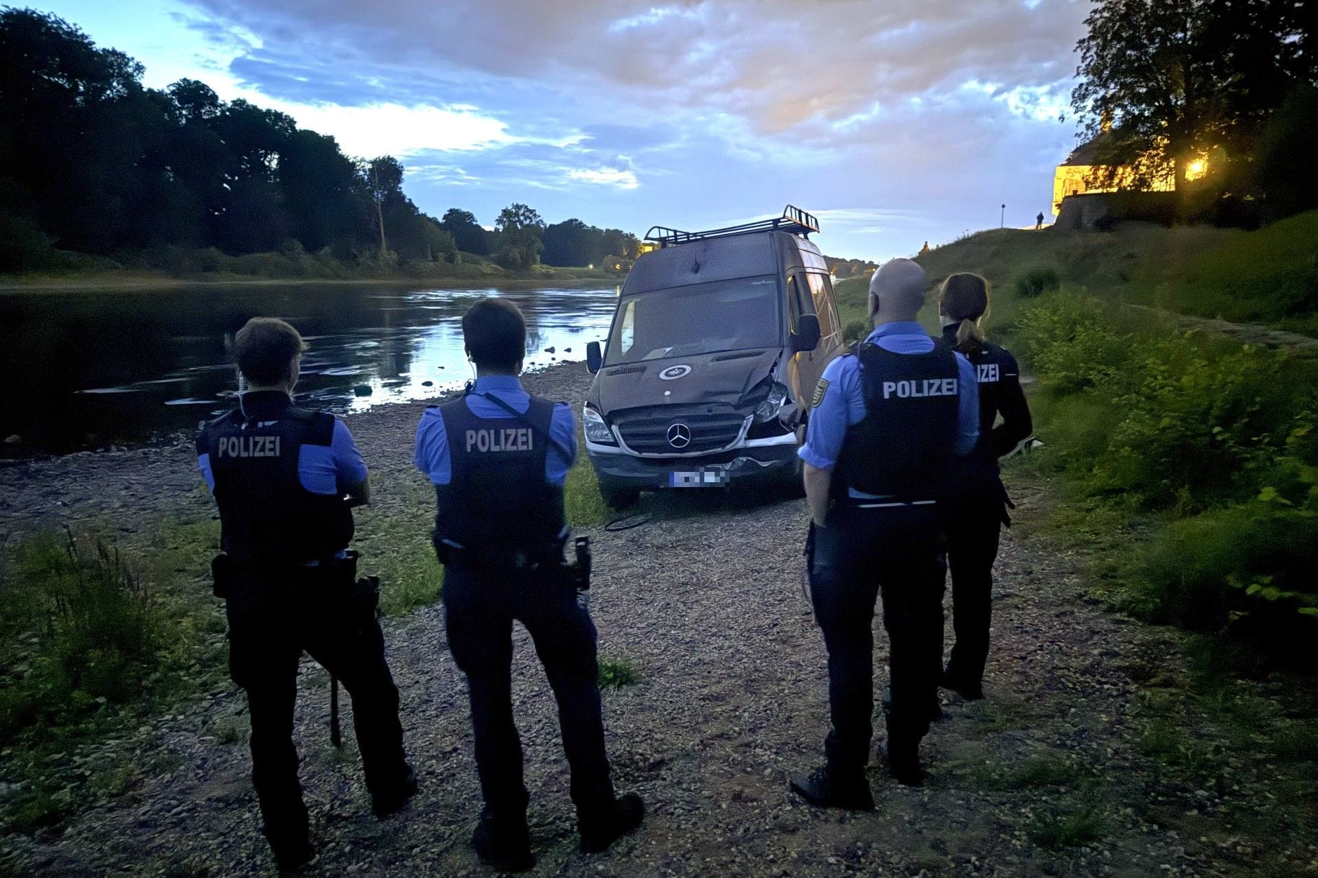 Dresdner Polizeibeamte mit dem verunglückten Transporter an der Elbe: Der Fahrer des Wagens wurde festgenommen.