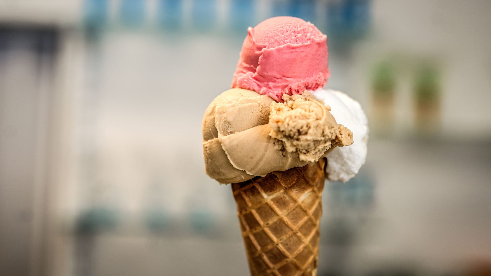 Drei Kugeln Eis im Hörnchen in einer Eisdiele (Symbolbild).