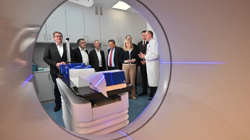 Blick durch einen einen Ethos-Linearbeschleuniger: Wolfgang Hoffmann (r.), Direktor der Klinik für Strahlentherpie, erklärt Nina Warken (CDU), Bundesgesundheitsministerin, und Andreas Philippi (SPD, 5.v.r.), Gesundheitsminister Niedersachsen, die Funktion.