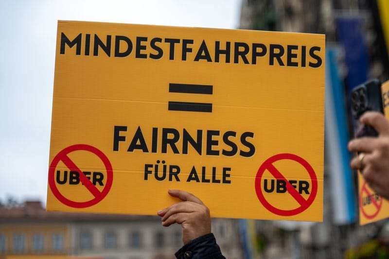 Ein Taxifahrer hält bei einer Demonstration auf dem Münchner Marienplatz ein Schild hoch: Bereits am Dienstag demonstrierten die Taxifahrer in München.