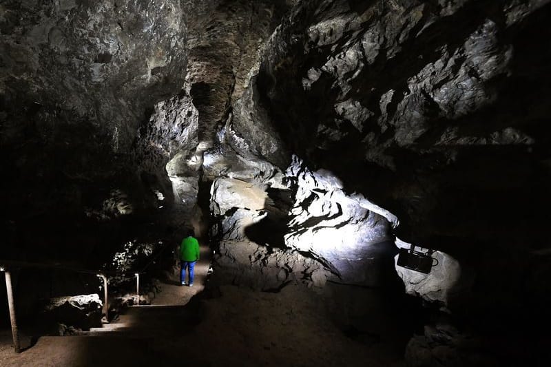 Eine Mitarbeiterin geht in der Kluterthöhle einen Weg entlang: Das Höhlensystem ist nach der Entdeckung eines Verbindungsgangs zur Bismarckhöhle nun das längste in NRW.