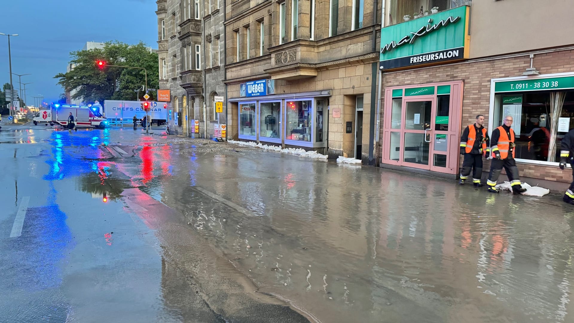 Die Einsatzstelle in der Maximilianstraße am frühen Mittwochmorgen: Die Straße ist überschwemmt, vor den Hauseingängen stellte die Feuerwehr Sandsäcke auf.