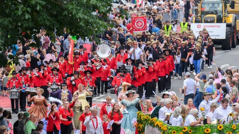 Teilnehmer gehen beim Schützenausmarsch in der Innenstadt: Zehntausende Besucher verfolgen den traditionellen Schützenumzug zum Schützenfest.
