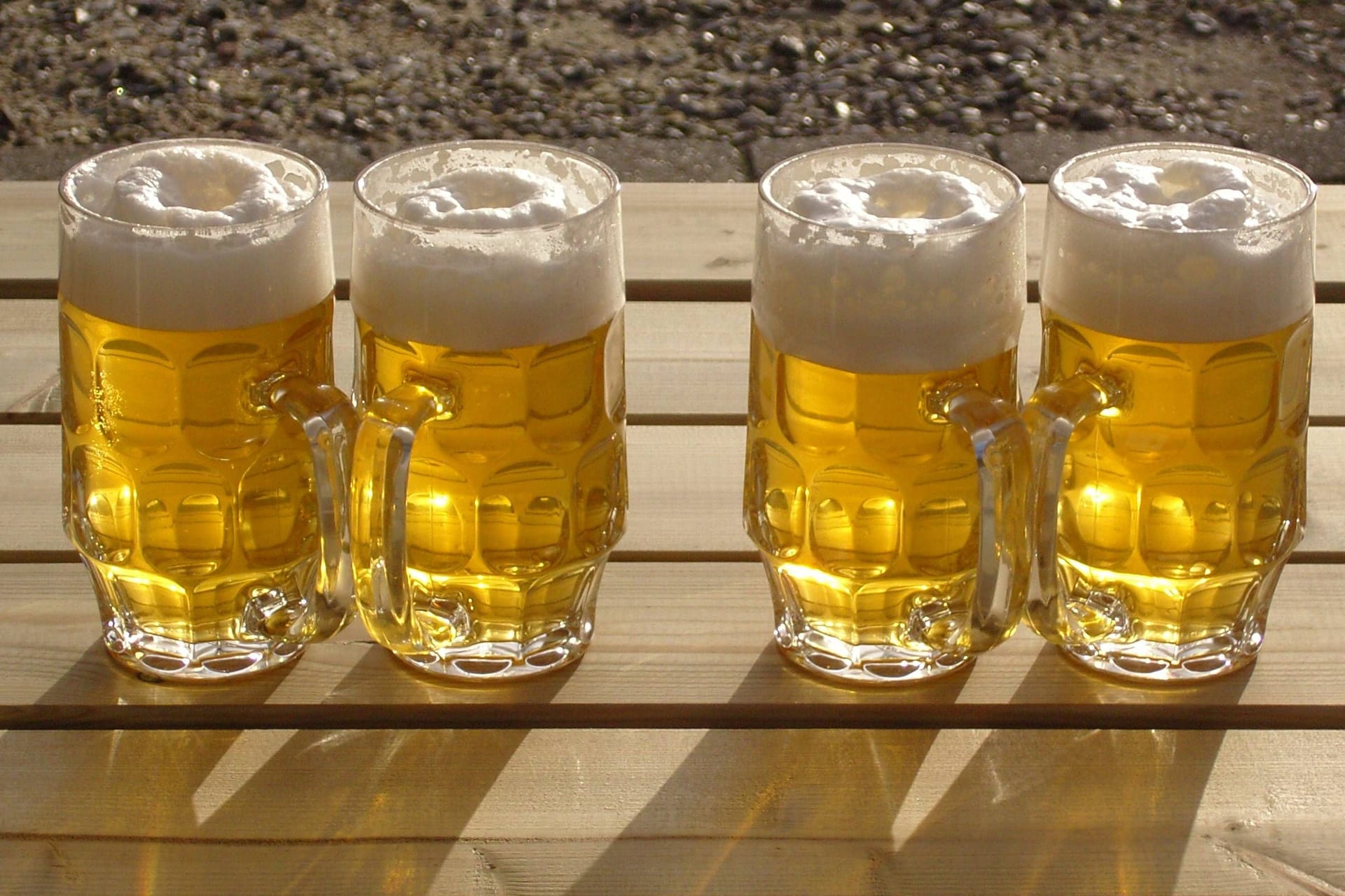 Vier frisch gezapfte Biere auf einem Holztisch (Symbolbild): 80 Biersommeliers aus 18 Nationen treten in München gegeneinander an.