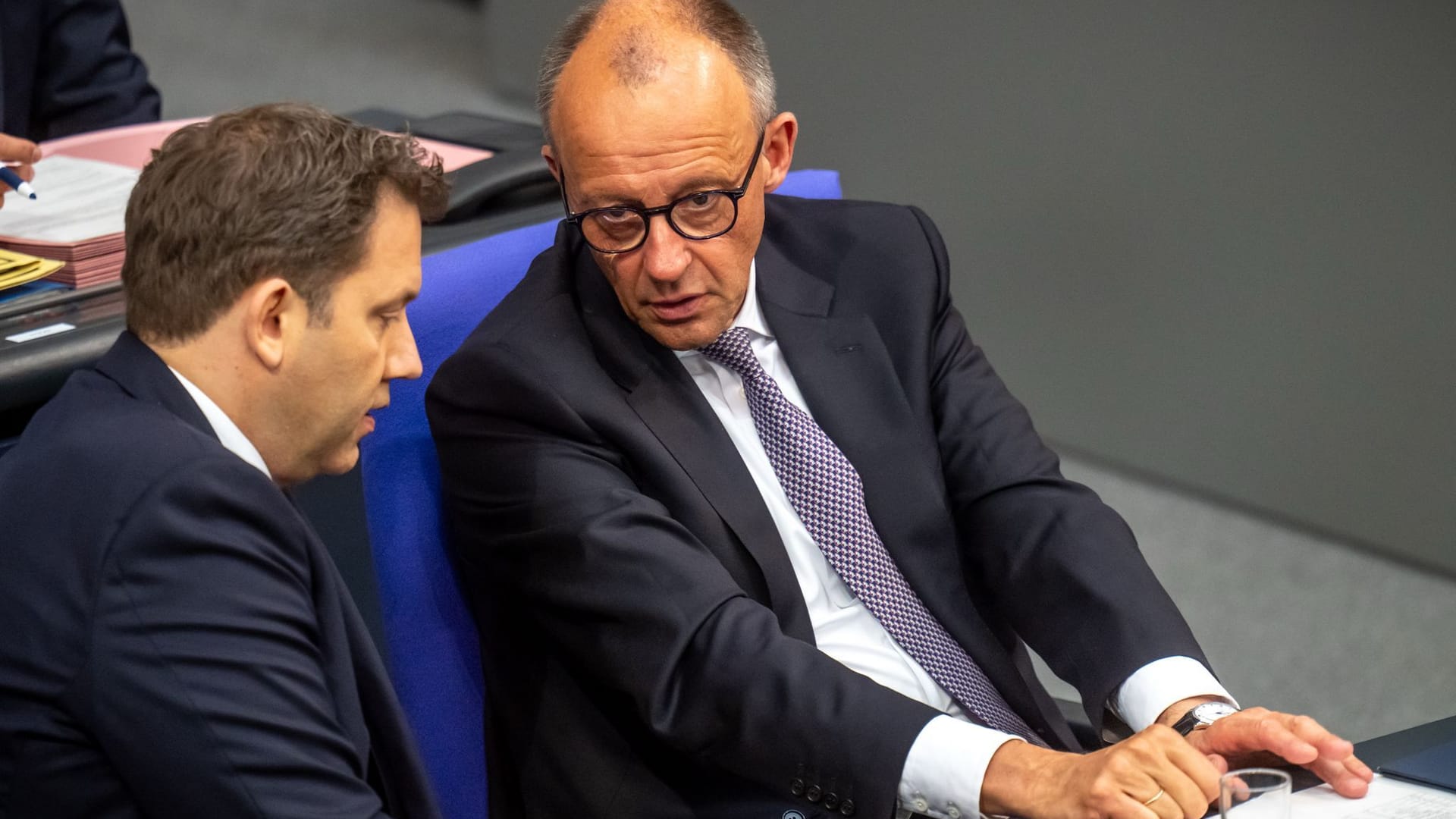 Bundeskanzler Friedrich Merz (CDU, r.) spricht mit Lars Klingbeil (SPD), Bundesminister der Finanzen, im Bundestag.