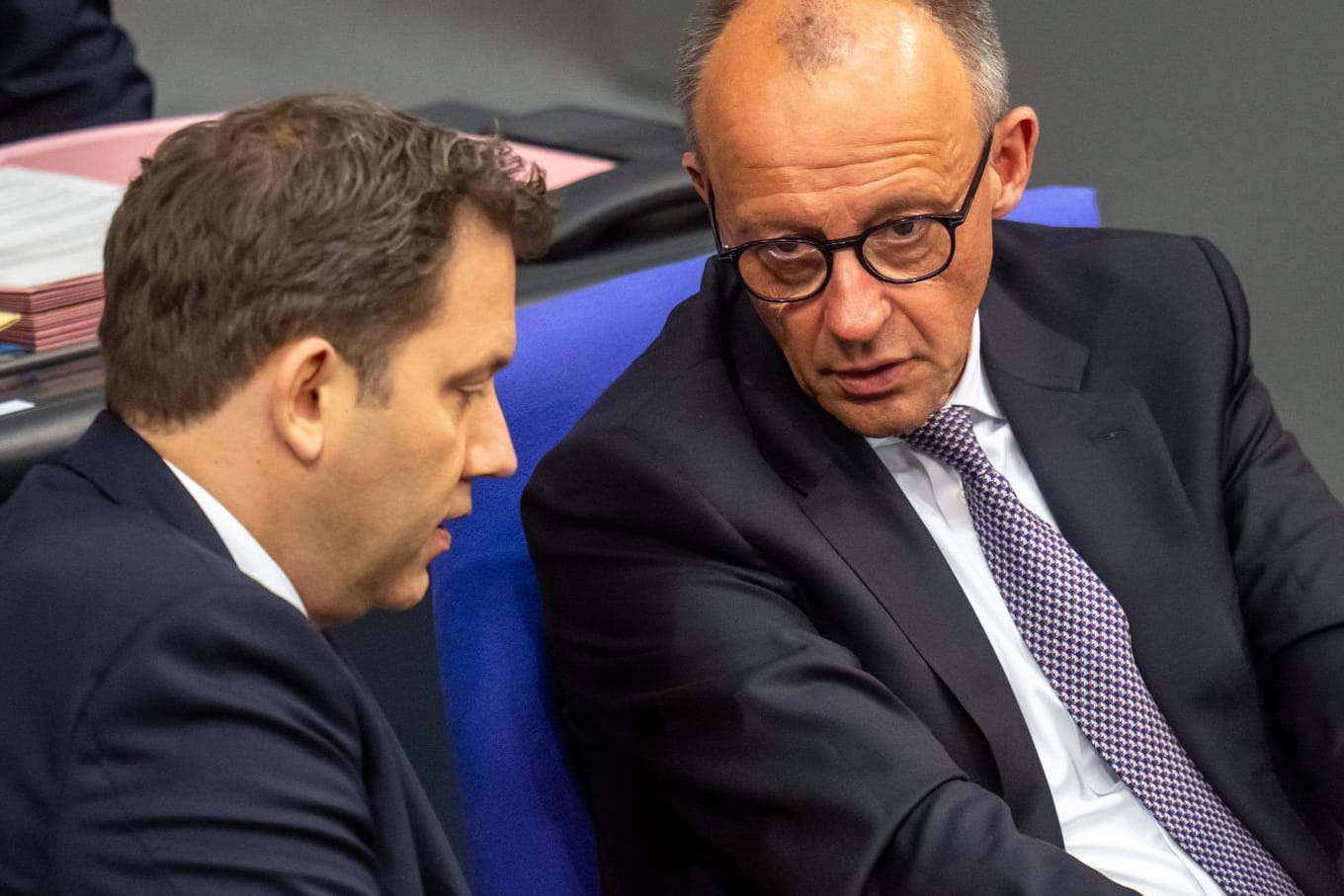 Bundeskanzler Friedrich Merz (CDU, r.) spricht mit Lars Klingbeil (SPD), Bundesminister der Finanzen, im Bundestag.