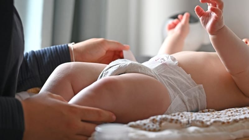 Eine Mutter schließt die Windel ihres Babys auf dem Wickeltisch (Symbolbild): Der Geburtenknick in Sachsen setzt sich fort. Eine Mutter schließt die Windel ihres Babys auf dem Wickeltisch (Symbolbild): Der Geburtenknick in Sachsen setzt sich fort.