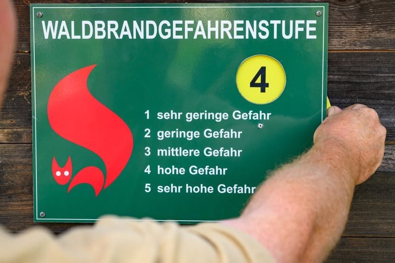 Am Schild des Landesbetriebs Forst Brandenburg wird die Warnstufe getauscht (Symbolbild): Am Samstag soll in Brandenburg an vielen Orten wieder eine hohe bis sehr hohe Waldbrandgefahr bestehen.