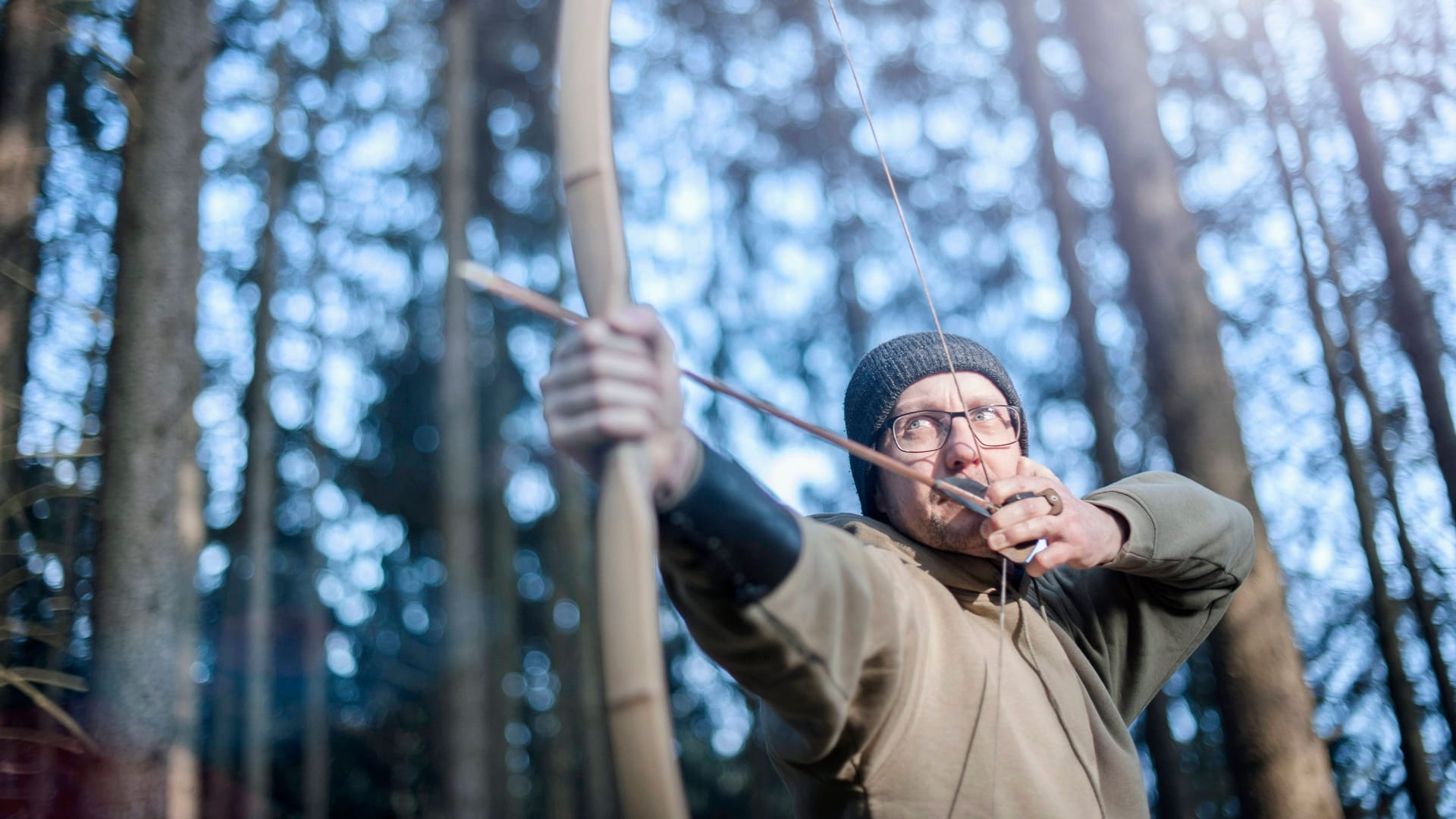 Ein Mann beim Bogenschießen (Symbolbild): Im Harz kann man während der Freizeitaktivität durch den Wald streifen.