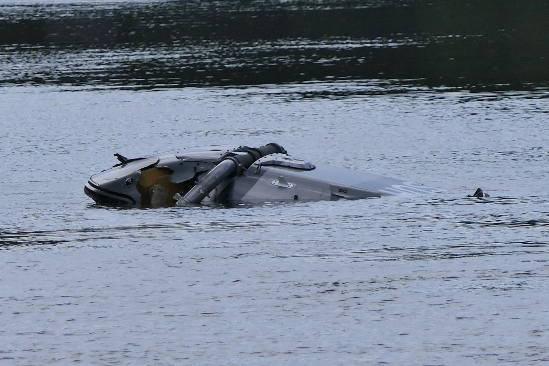 Ein Hubschrauberg treibt in der Nähe von Grimma in Sachsen in einem Fluss.