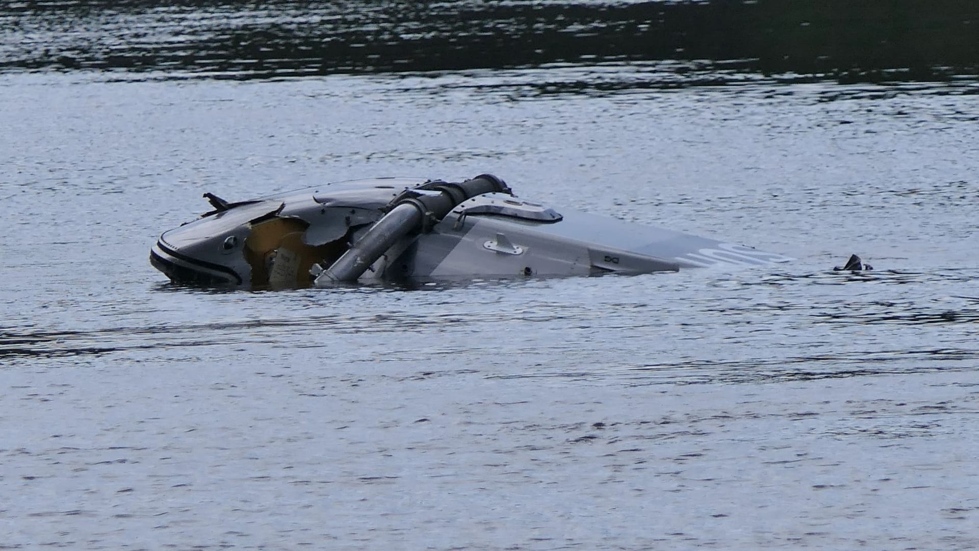 Ein Hubschrauberg treibt in der Nähe von Grimma in Sachsen in einem Fluss.